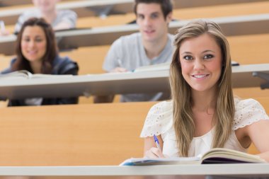 Students sitting at the lecture hall smiling clipart