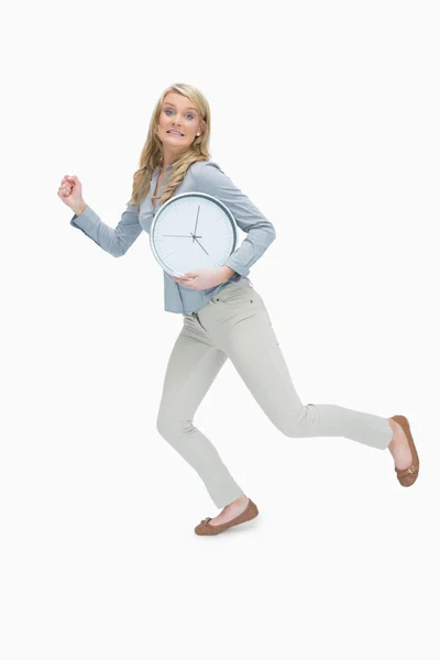 Женщина бежит, держа часы — стоковое фото