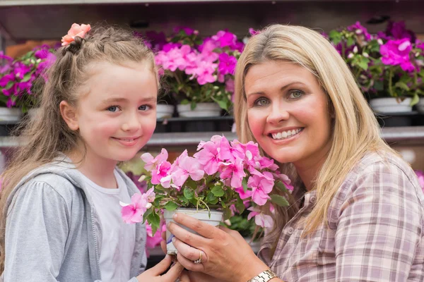 Madre e hija sosteniendo una planta — Foto de Stock