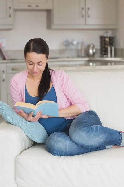 Mujer joven leyendo en la sala de estar — Foto de Stock