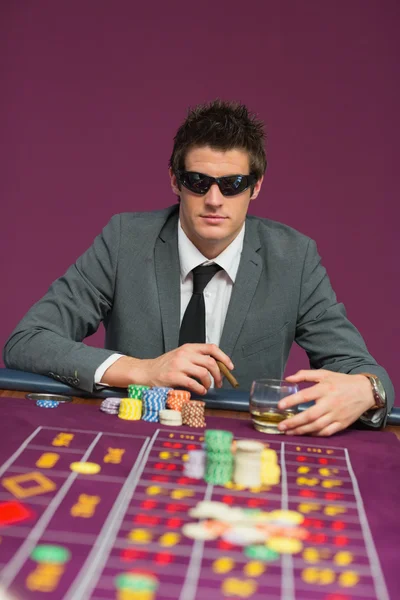 Man wearing sun glasses at roulette table — Stock Photo, Image