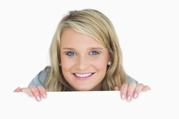 Smiling woman looking over poster — Stock Photo, Image