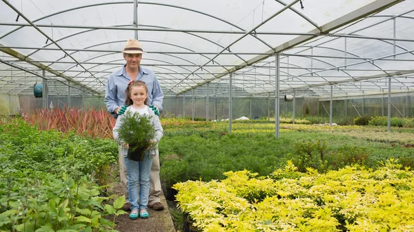 Садовник и внучка держат в руках большой горшок — стоковое фото