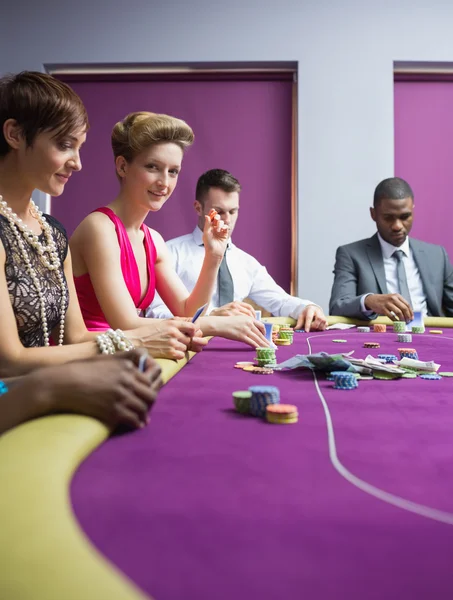 Mujer sonriendo y mirando hacia arriba desde el poker juego — Foto de Stock