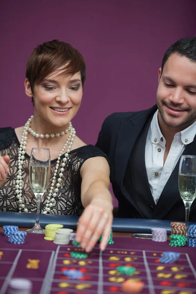 Vrouw plaatsen roulette wedden met man — Stockfoto