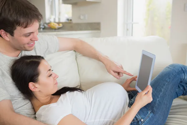 Prospective parents relaxing with tablet pc — Stock Photo, Image