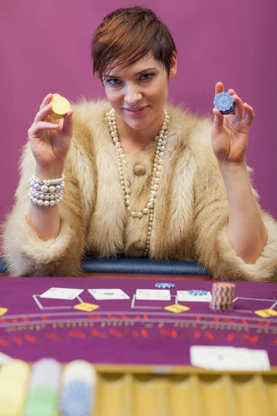 Woman holding up chips at poker game — Stock Photo, Image