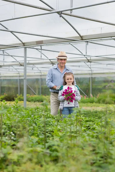 紫の花を保持している孫娘と立っている人 — ストック写真