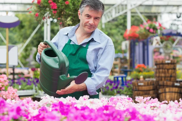 Blumenhändler gießt Blumen — Stockfoto