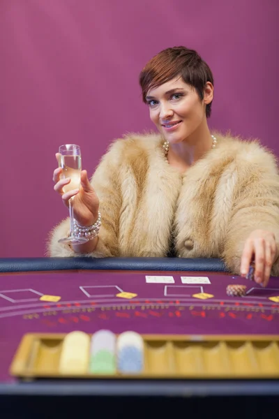 Woman drinking at table of a casino — Stock Photo, Image