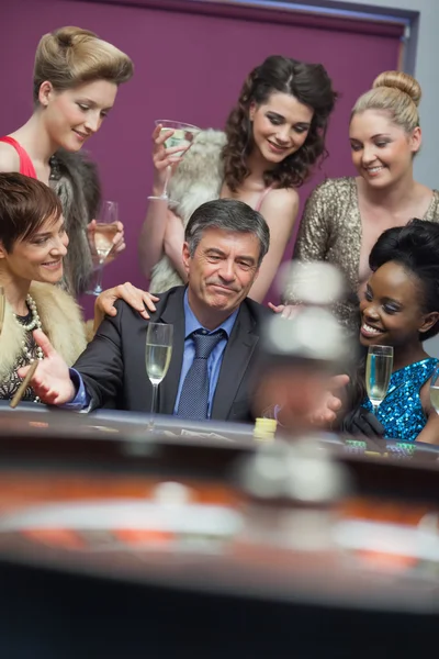Man surrounded by women accepting of loss — Stock Photo, Image