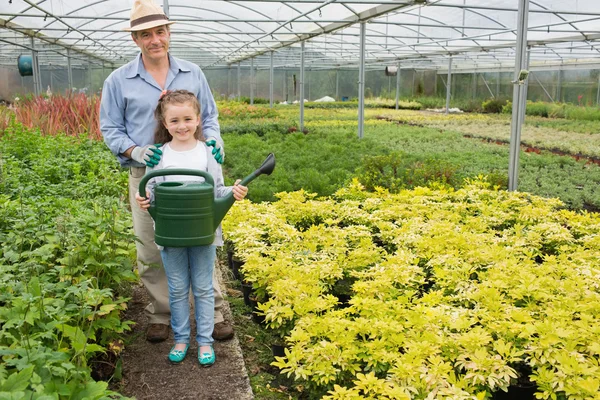 Gardener with granddaughter holding watering can — Stock Photo, Image