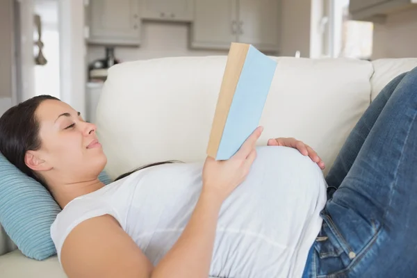 Zwangere vrouw met een hand op haar buik — Stockfoto