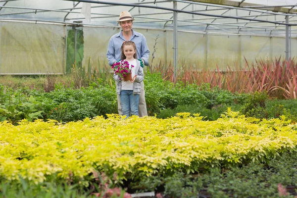 Jardineiro com neto segurando flor roxa — Fotografia de Stock