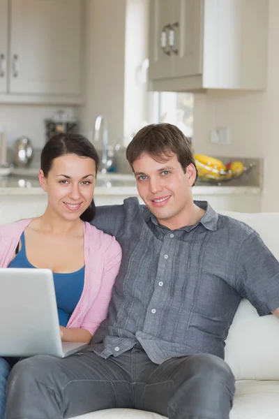 Casal jovem relaxante ao usar o laptop — Fotografia de Stock