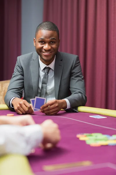 Uomo sorridente che alza lo sguardo dal poker — Foto Stock