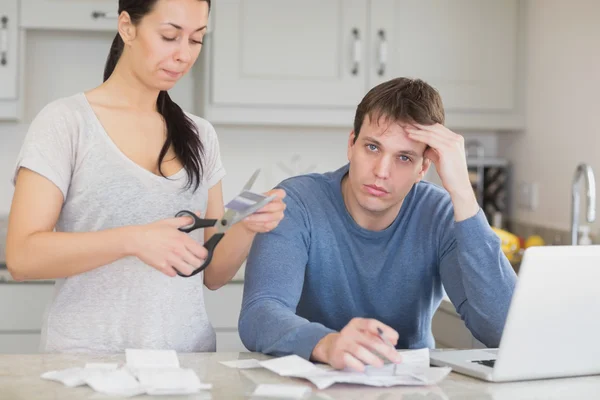 Disappointed woman cutting through a credit card — Stock Photo, Image