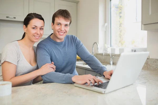 Heureux jeune couple en utilisant un ordinateur portable — Photo