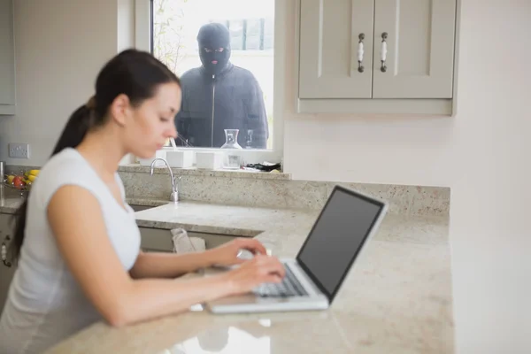 Burglar observing woman in the kitchen — Stock Photo, Image