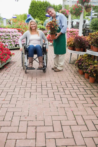 Garden center employee and woman in wheelchair — Stock Photo, Image