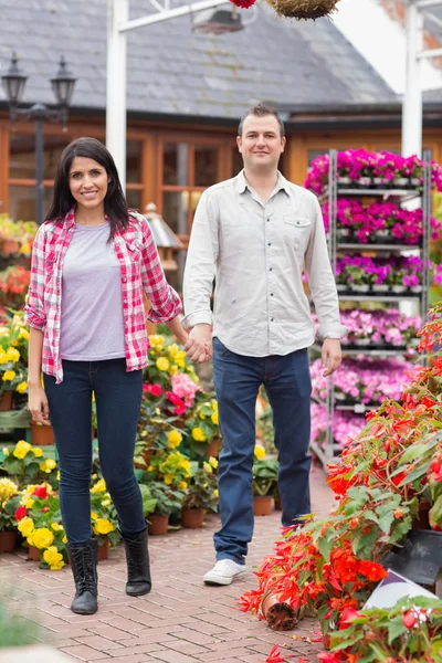 Couple holding hands in garden center — Stock Photo, Image