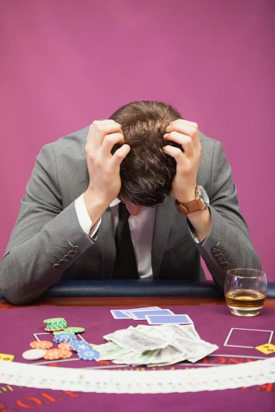 Depressed man playing poker — Stock Photo, Image