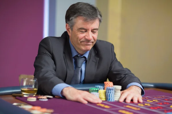 Un homme assis à table regardant des chips — Photo