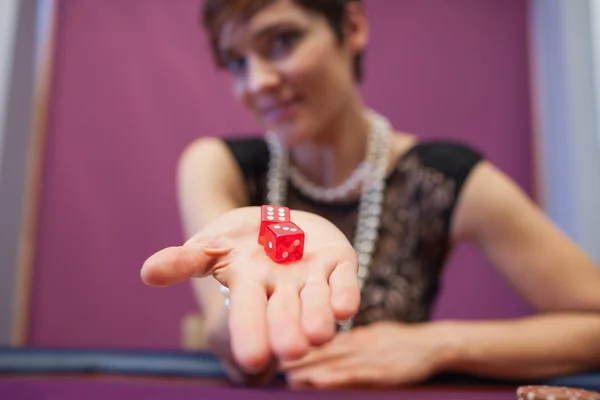 Woman holding dices at table — Stock Photo, Image