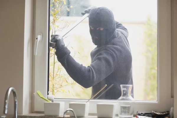 Ladrón rompiendo una ventana de la cocina —  Fotos de Stock