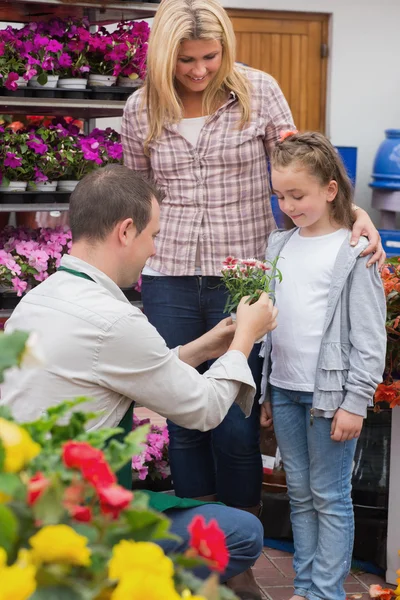 Kleines Mädchen bekommt Geschenk von Gartencenter-Mitarbeiterin — Stockfoto