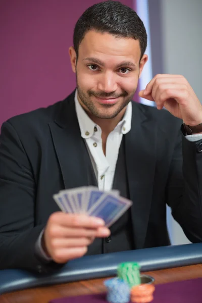 Hombre sosteniendo sus cartas — Foto de Stock