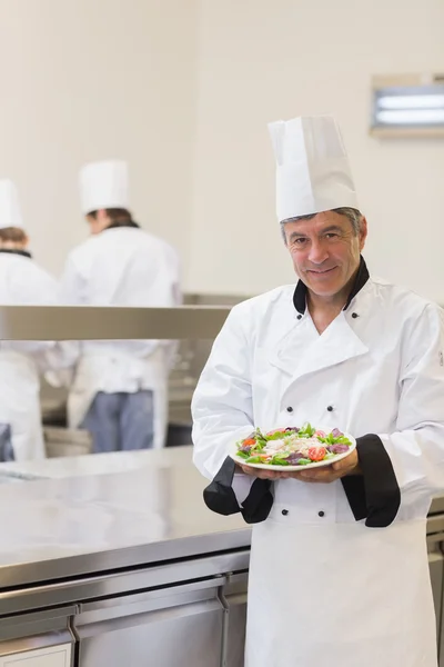 Kocken visar sin sallad i köket — Stockfoto