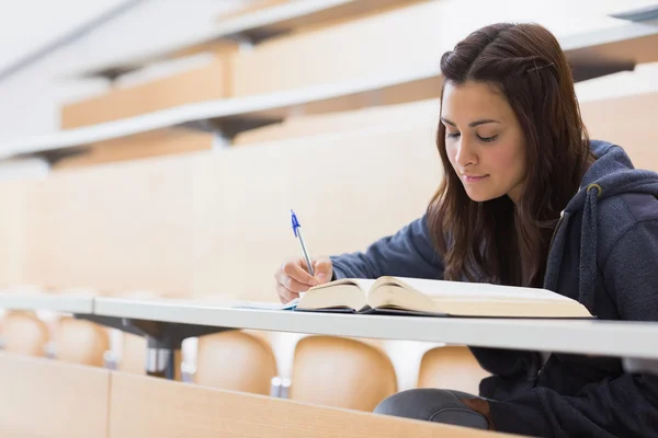 Menina lendo um livro e escrevendo notas — Fotografia de Stock