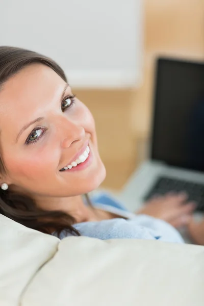 Ευτυχισμένη γυναίκα χρησιμοποιώντας φορητό υπολογιστή στον καναπέ — Φωτογραφία Αρχείου