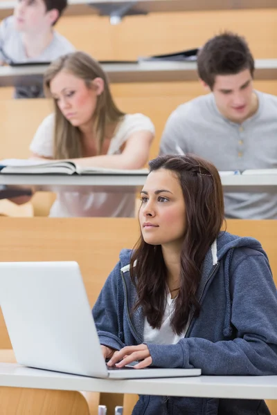 Girl sitting at the lecture hall concentrating — Stock Photo, Image