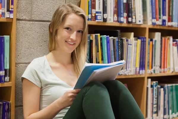 Vrouw zitten in de bibliotheek op de verdieping — Stockfoto