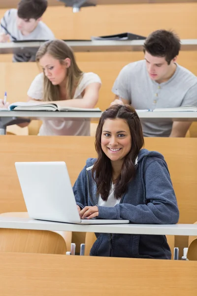 Lachende student in lezing met laptop — Stockfoto