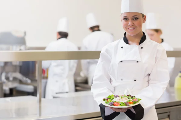 Lachende chef-kok tonen haar salade — Stockfoto