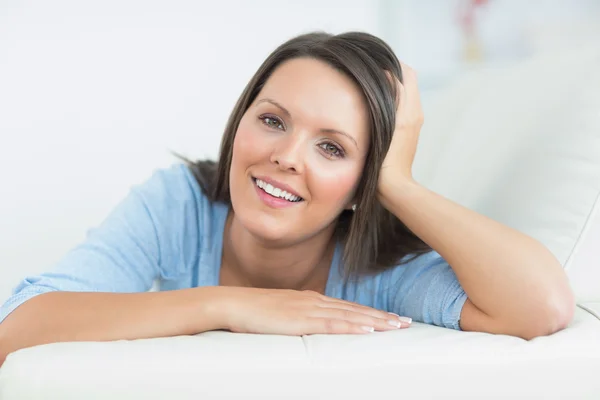 Femme souriante couchée sur le canapé — Photo