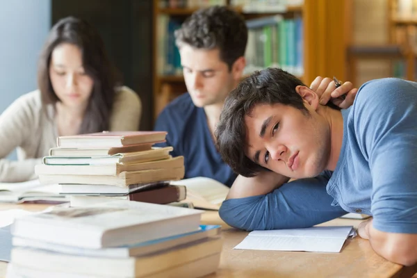 Estudante cansado descansando na biblioteca — Fotografia de Stock