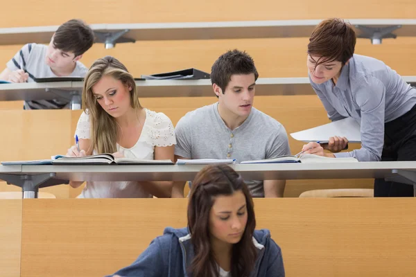 Studenti sedí v přednáškovém sále, zatímco učitel vysvětlí — Stock fotografie