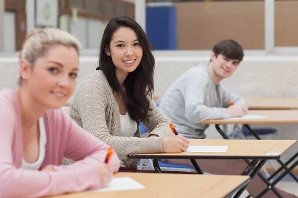 Glada studenter tittar upp från gör examen — Stockfoto