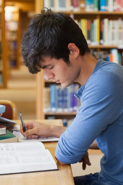 Estudante estudando na biblioteca — Fotografia de Stock