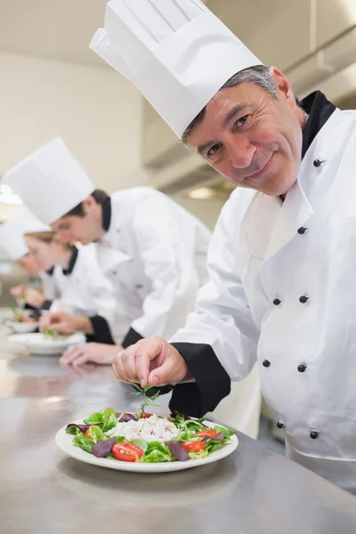 Lo chef allegro sta preparando le insalate. — Foto Stock