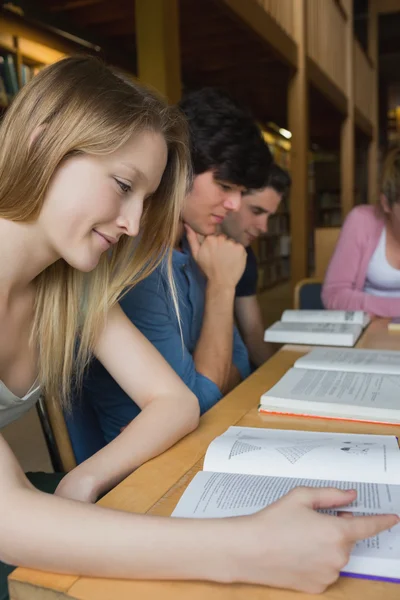 Φοιτητές που σπουδάζουν γύρω από τραπέζι βιβλιοθήκη — Φωτογραφία Αρχείου