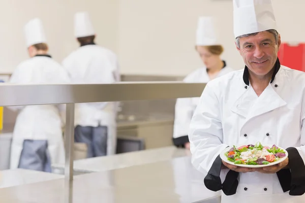 Lachende chef-kok presenteert zijn salade — Stockfoto