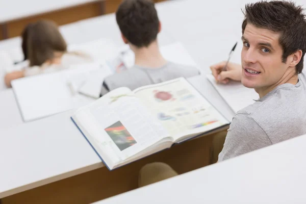 Man sitting at the lecture hall making notes — Stock Photo, Image