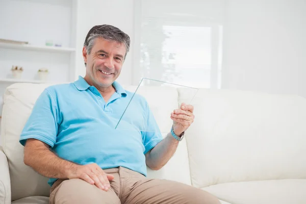 Man holding a pane while sitting on the sofa — Stock Photo, Image