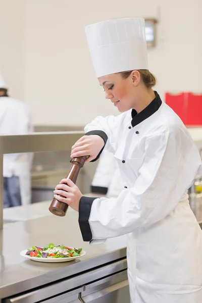 Chef cocinando una ensalada con pimienta — Foto de Stock