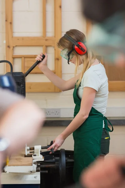 Woman standing at a drilling machine — Stock Photo, Image